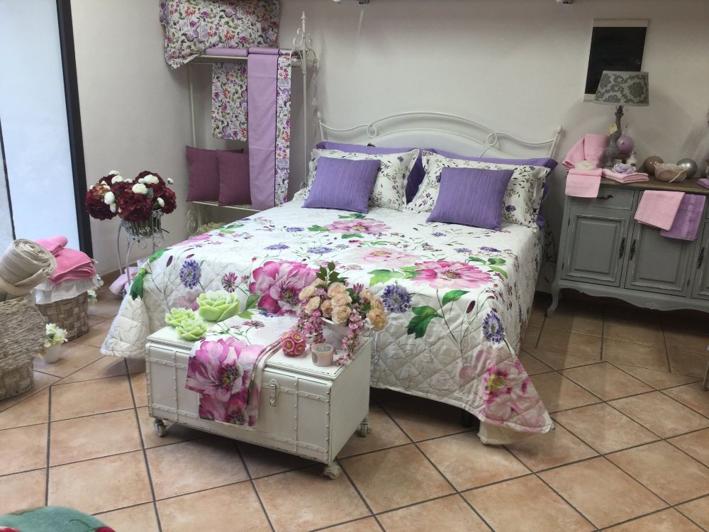 Trapunta letto floreale con cuscini viola