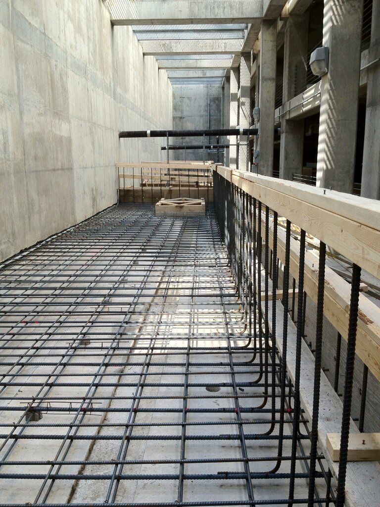 A construction site with a concrete floor and a metal fence