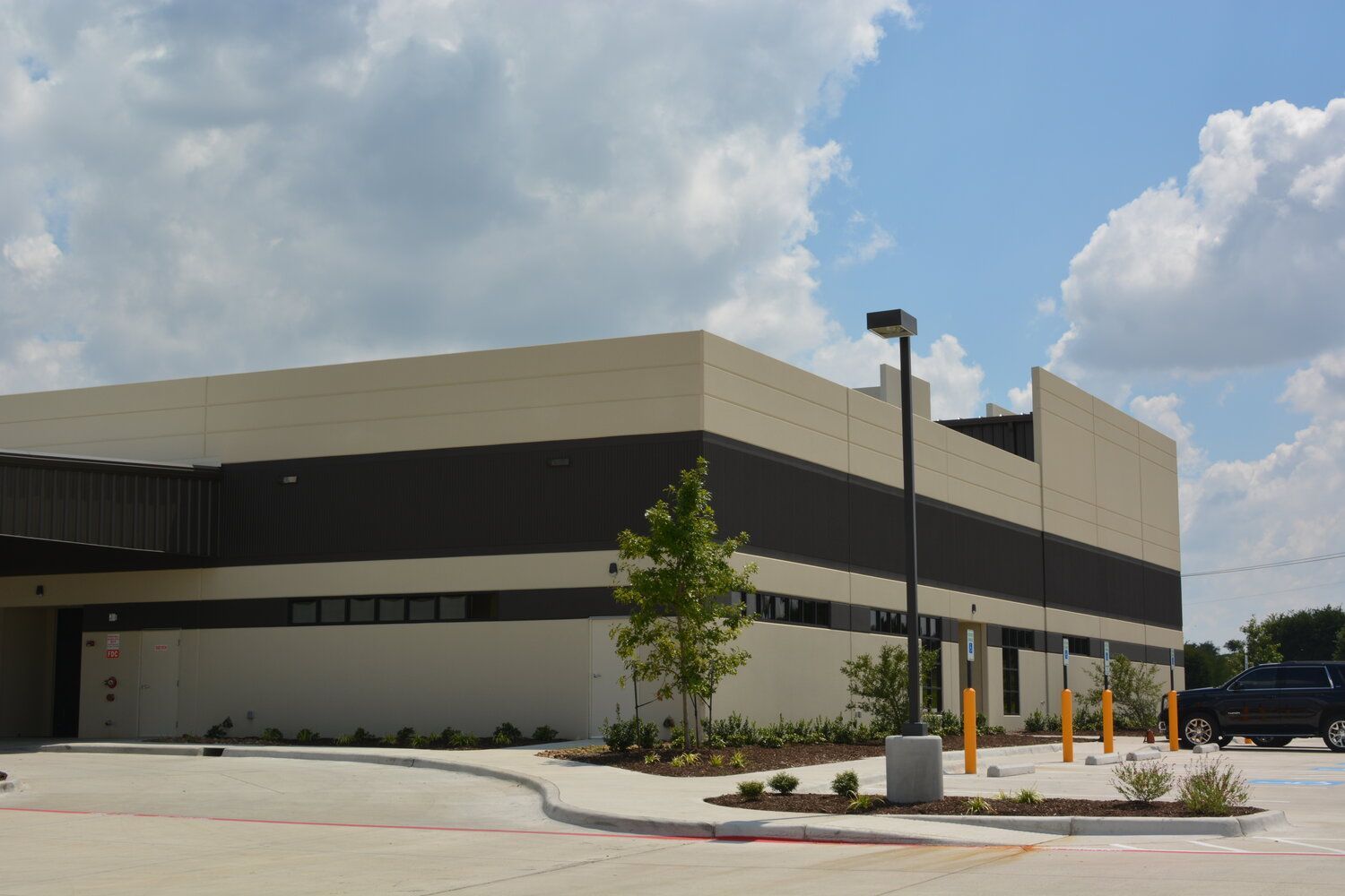A large Fort Worth building with a concrete parking lot in front of it