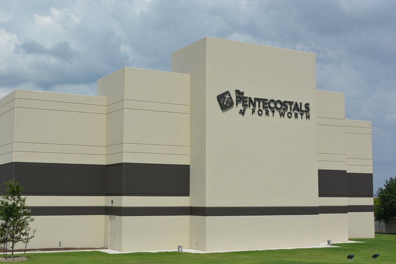 A large concrete building with a sign that says pentecostal fort worth