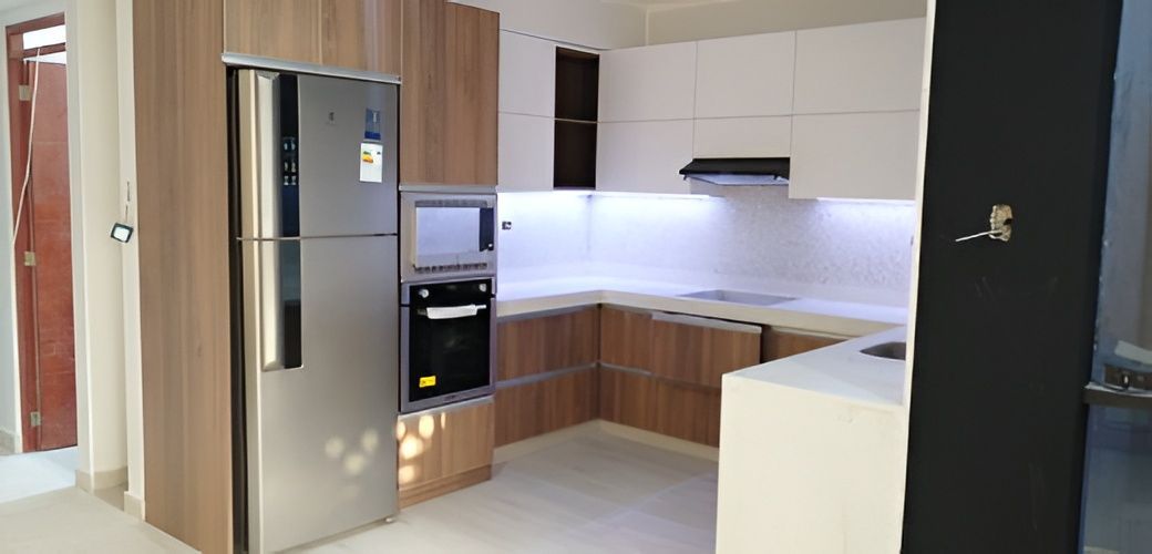 Un artesano trabaja en una losa de mármol en un taller, midiendo con una herramienta en un banco de trabajo.