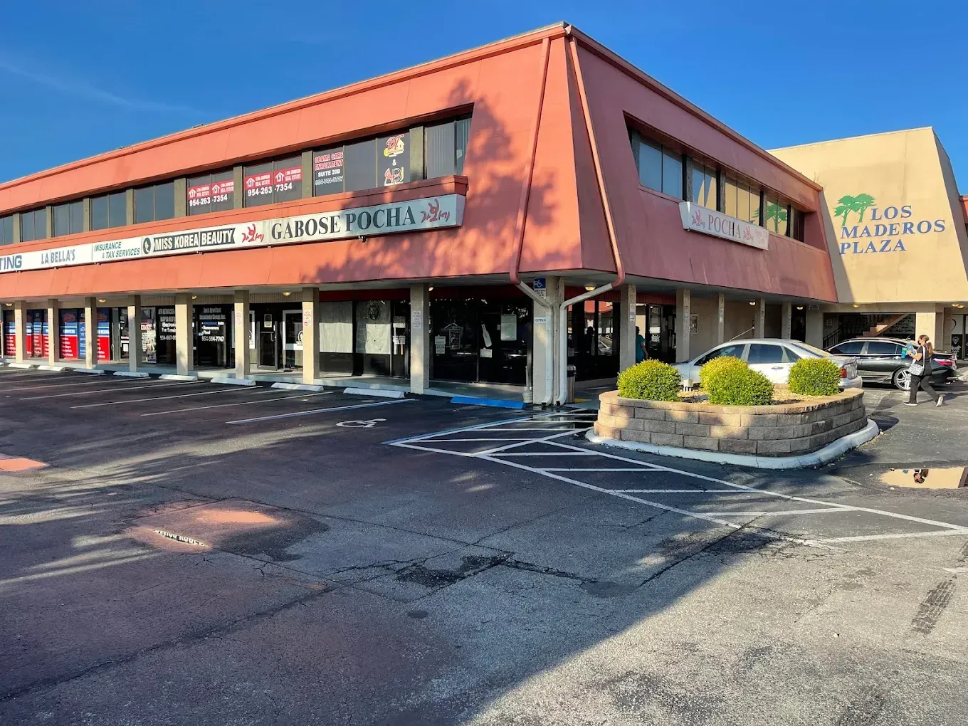 A two-story commercial building in Titus Boulevard Plaza with shops and parking.