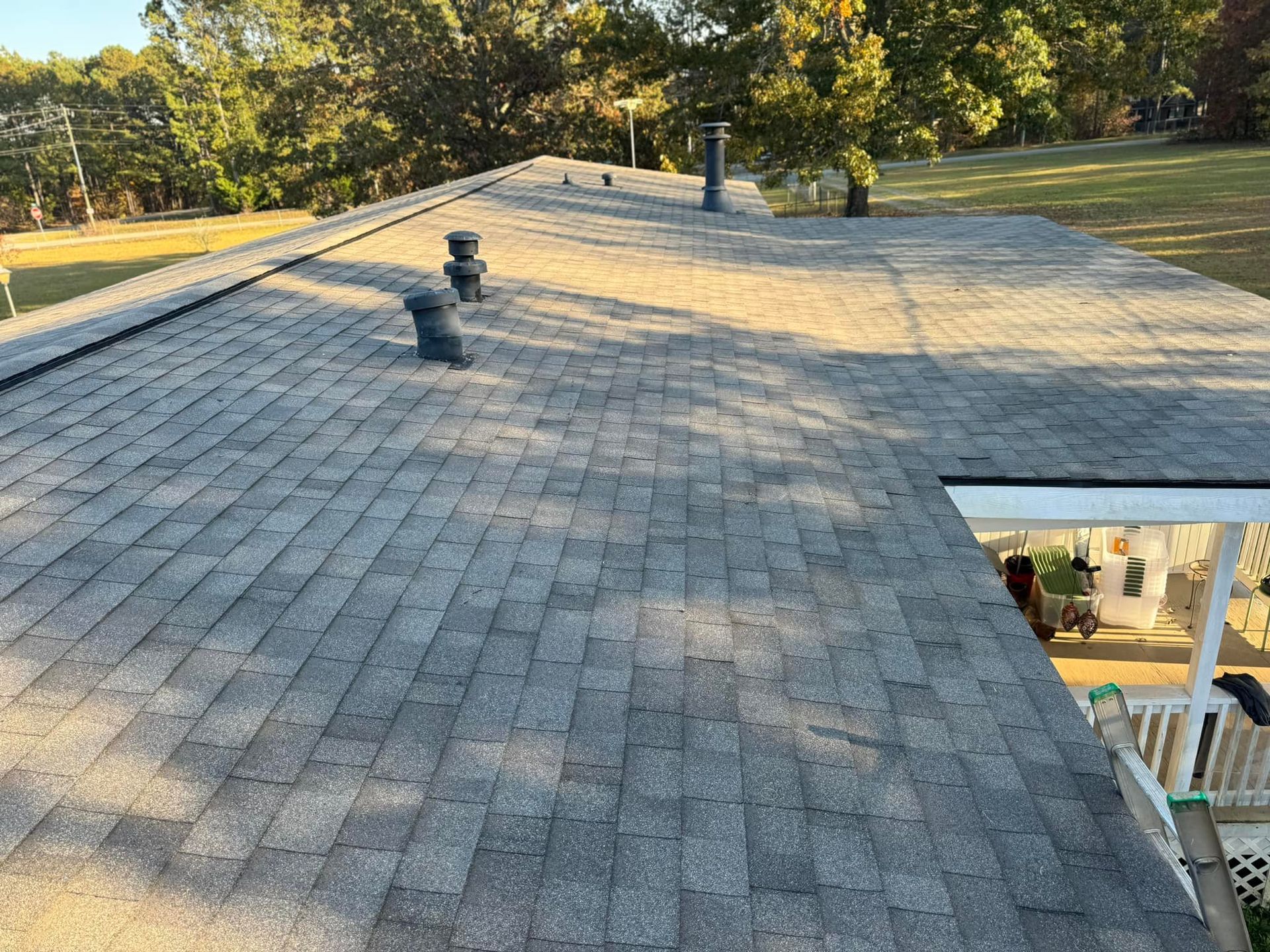 The roof of a house with a gray shingle roof.