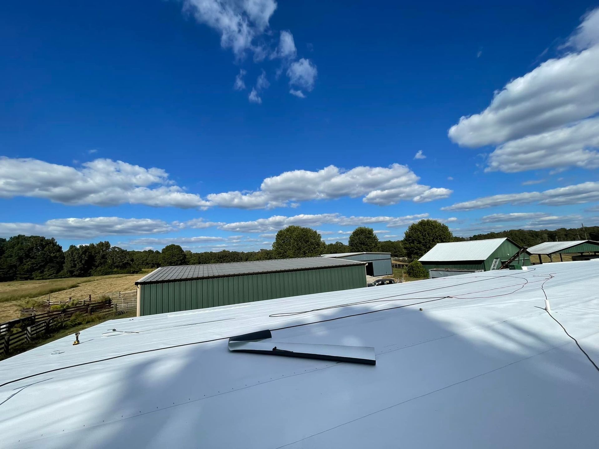 A white roof with a blue sky and clouds in the background.
