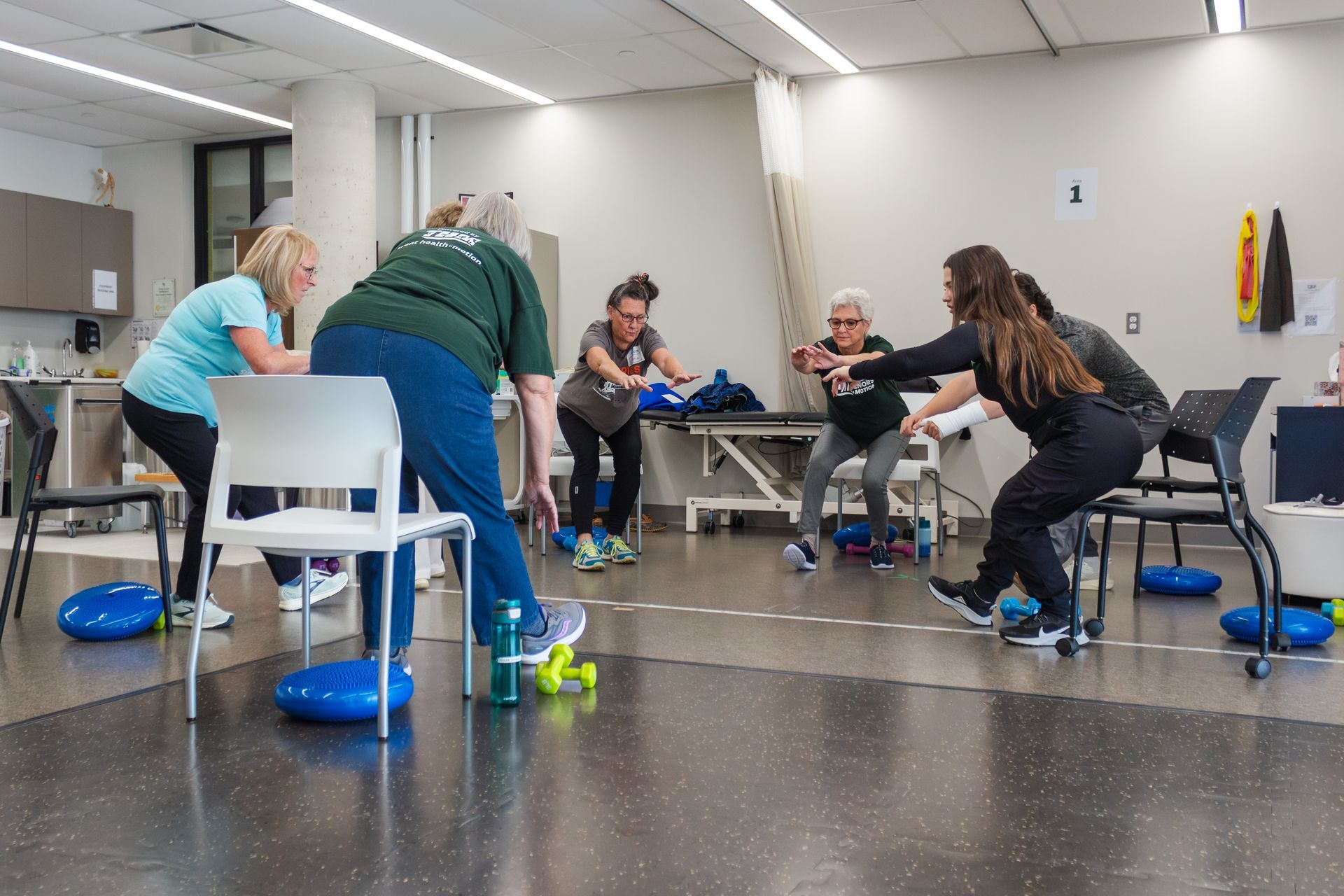 A group of women are doing exercises in a gym.