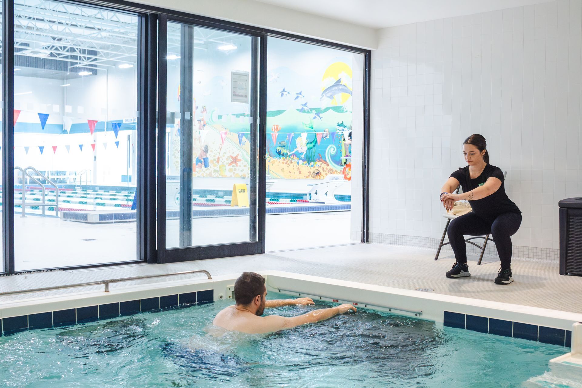 A woman is walking on a treadmill underwater in a swimming pool.
