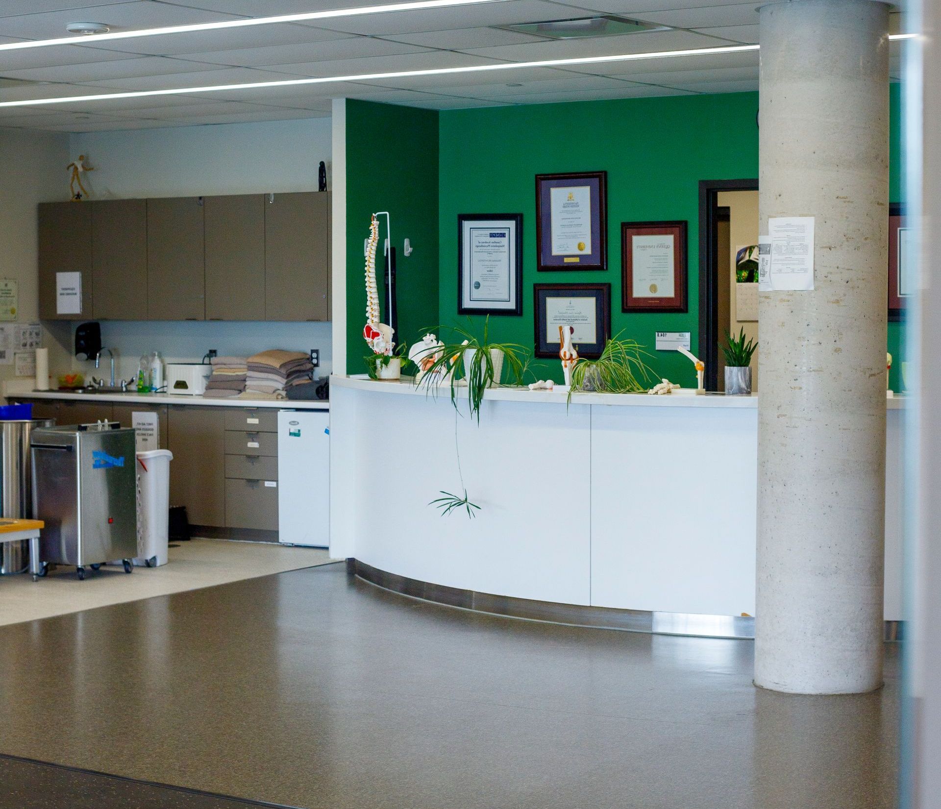 A hospital lobby with a green wall and a white counter