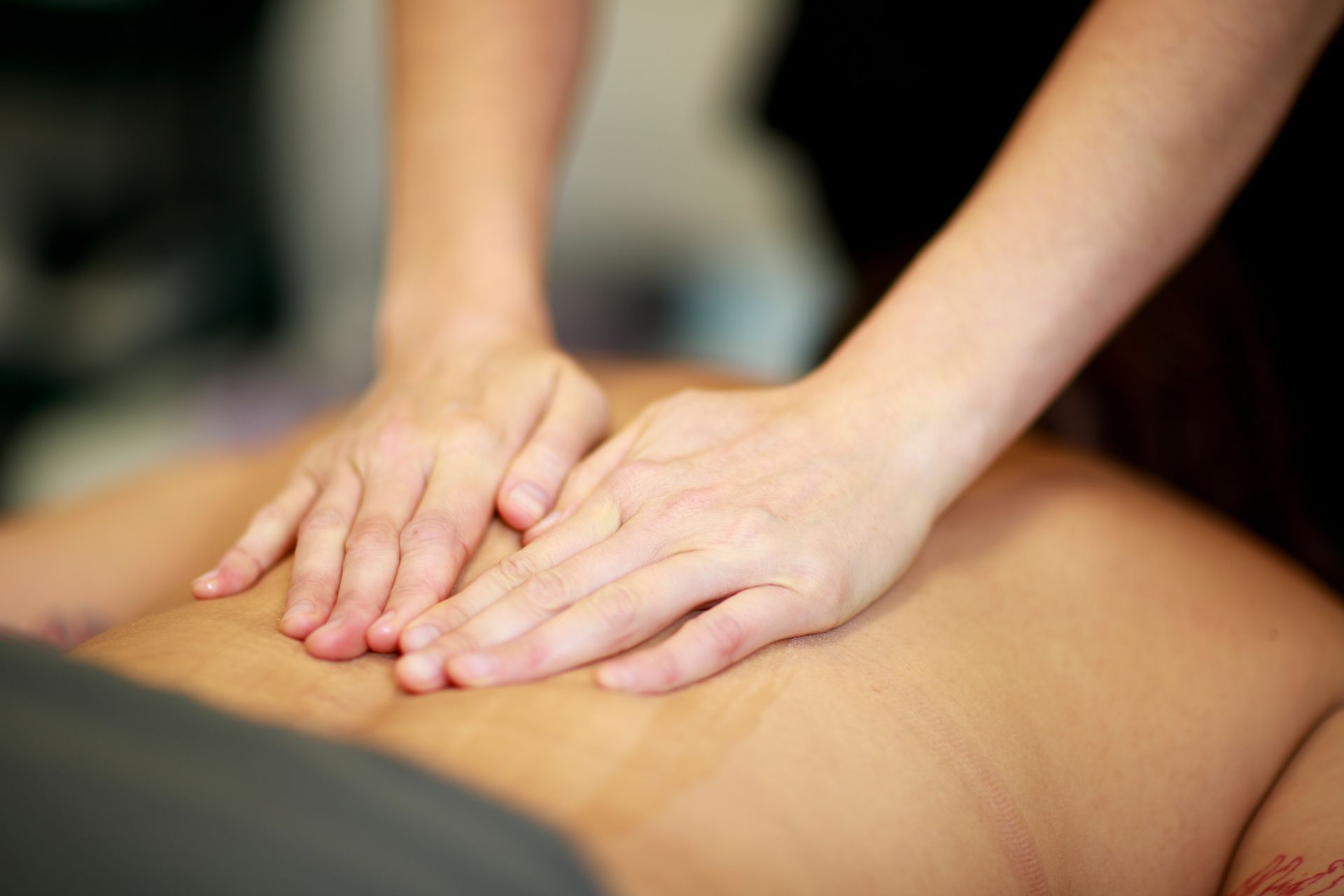 A woman is giving a man a massage on his back.