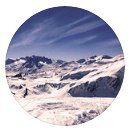 Montanhas cobertas de neve sob um céu azul límpido.