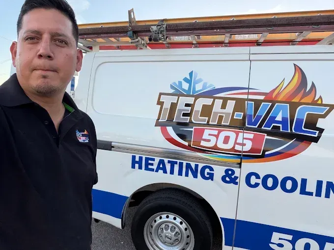 Man standing beside a TECH-VAC 505 heating and cooling van with blue and orange graphics