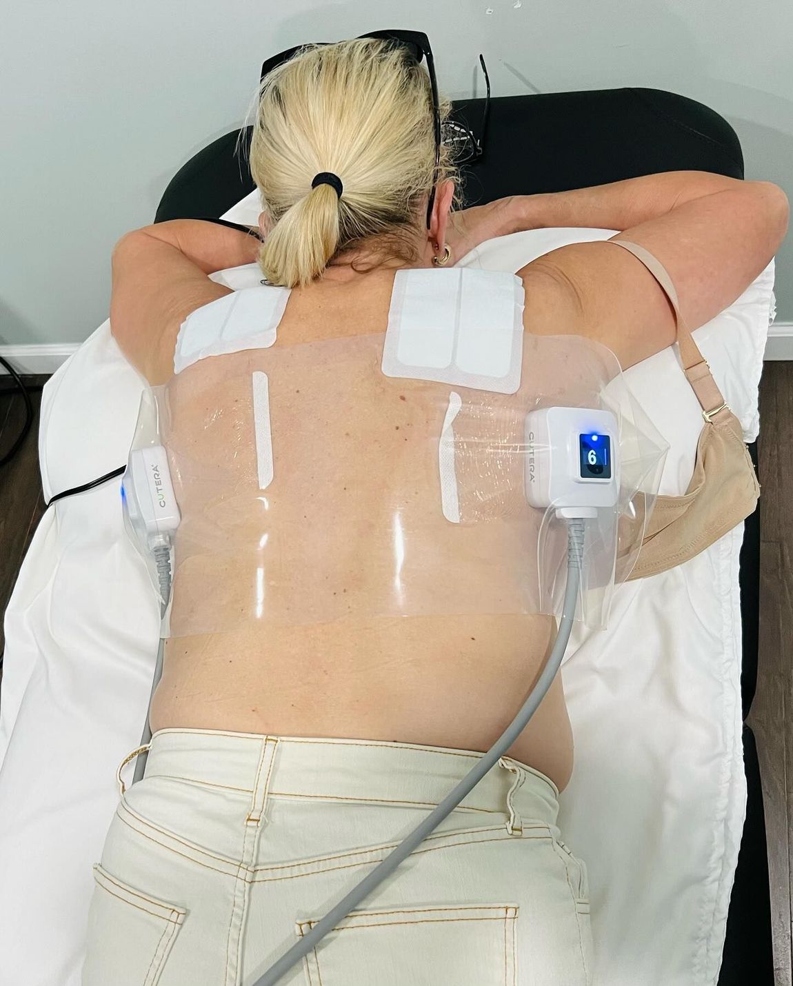 A Woman Is Laying on A Bed with A Machine on Her Back — LaGrange, GA — LaGrange Body Lab