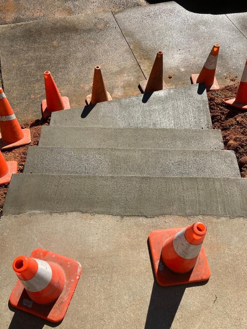 a group of orange and white traffic cones are sitting on a set of stairs