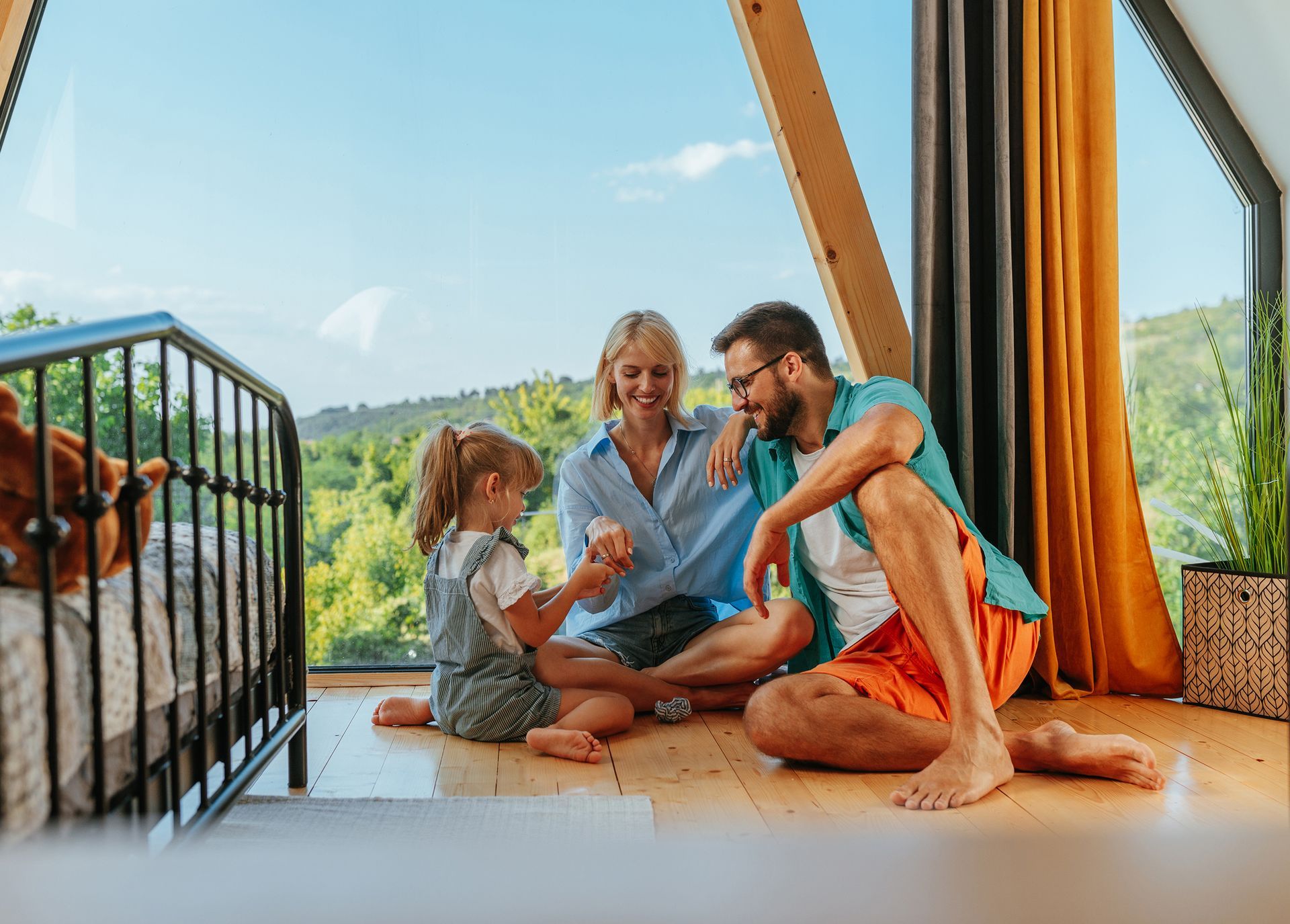 A family is sitting on the floor in front of a window.