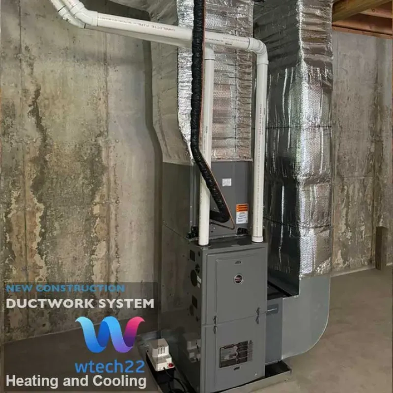 HVAC system with ductwork in a basement setting. Gray furnace, silver ductwork, and exposed concrete wall.