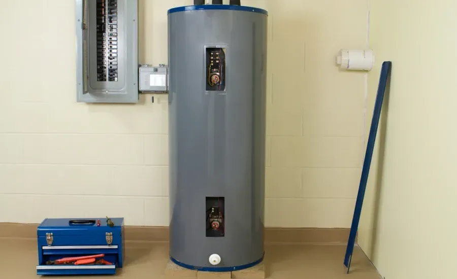 Electric water heater in a basement next to a blue toolbox, breaker box, and pipe.
