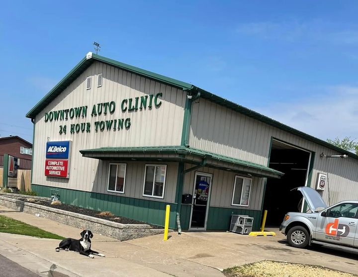 Downtown Auto Clinic building with a dog, a truck, and a partially open garage door | Downtown Auto Clinic