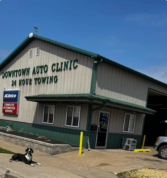 Downtown Auto Clinic building with a dog resting in front. Blue sky | Downtown Auto Clinic