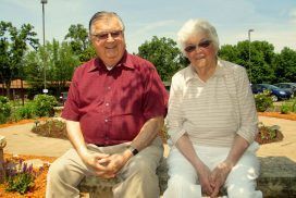 A man and a woman are sitting next to each other on a bench.