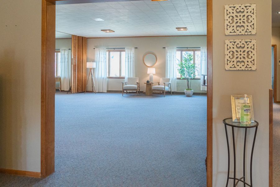 A large room with a blue carpet and a table in the middle of it.