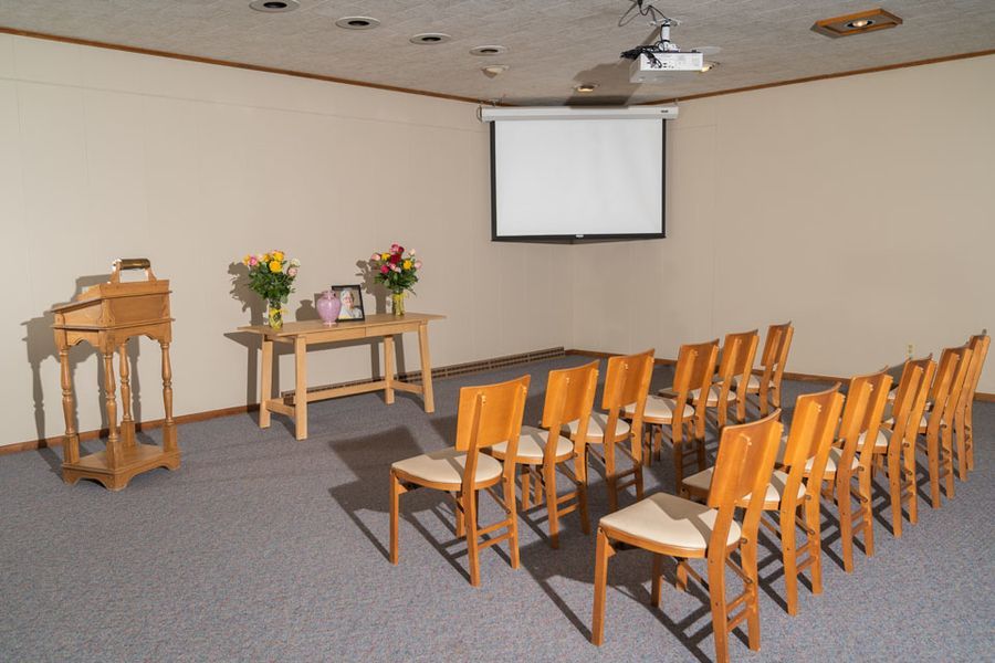 A room with rows of chairs and a projector screen