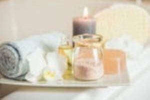 A tray with towels , candles , and soap on it.