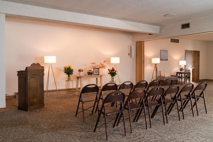 A row of folding chairs in a room with a podium.