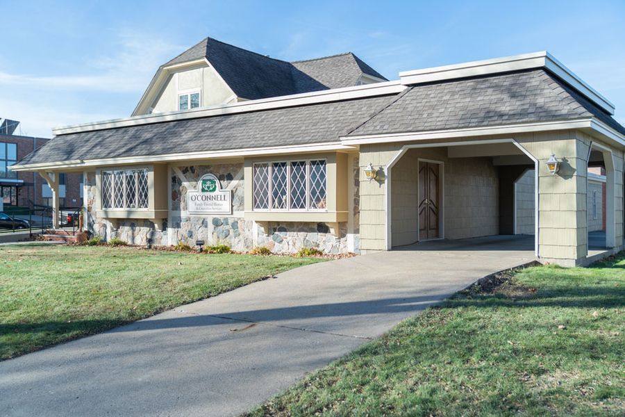 A large house with a lot of windows and a driveway in front of it.