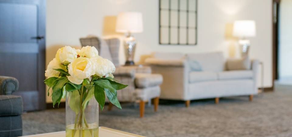 A vase of flowers is sitting on a table in a living room.