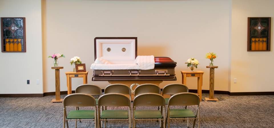 A room with chairs and a coffin in it