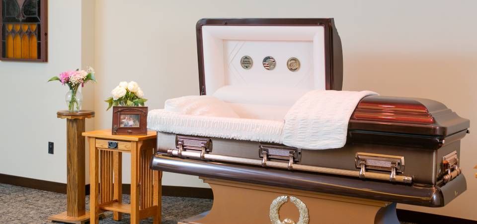 A coffin is sitting on a table in a room with the lid open.