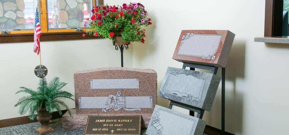 A room with a display of grave stones and a plant.