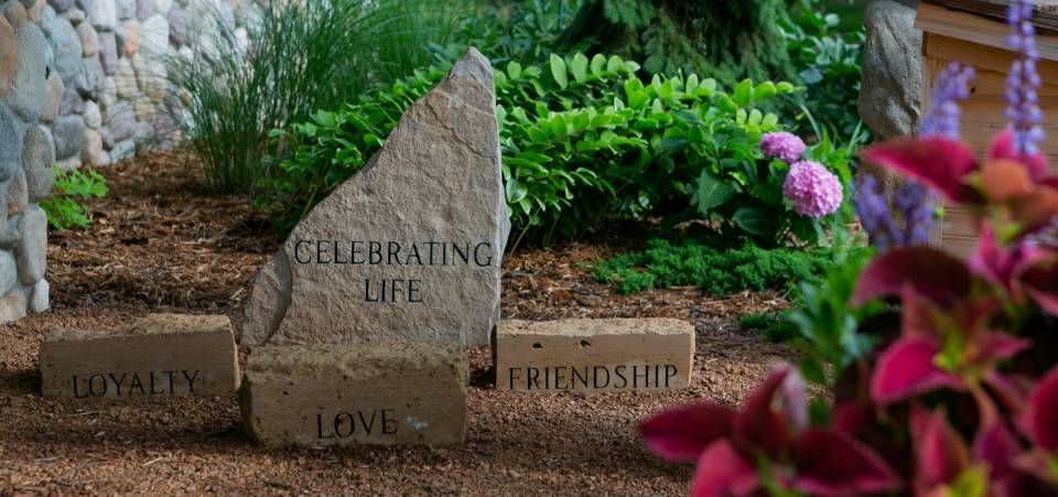 A stone with the words celebrating life , loyalty , love and friendship written on it.