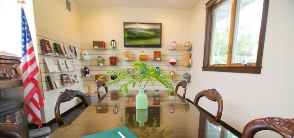 A conference room with a long table and chairs and an american flag.