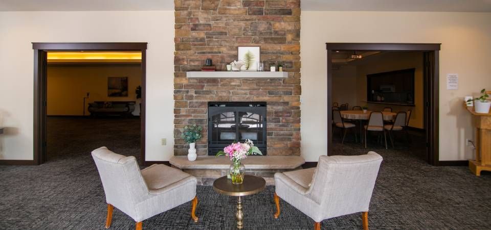 A living room with two chairs and a fireplace.