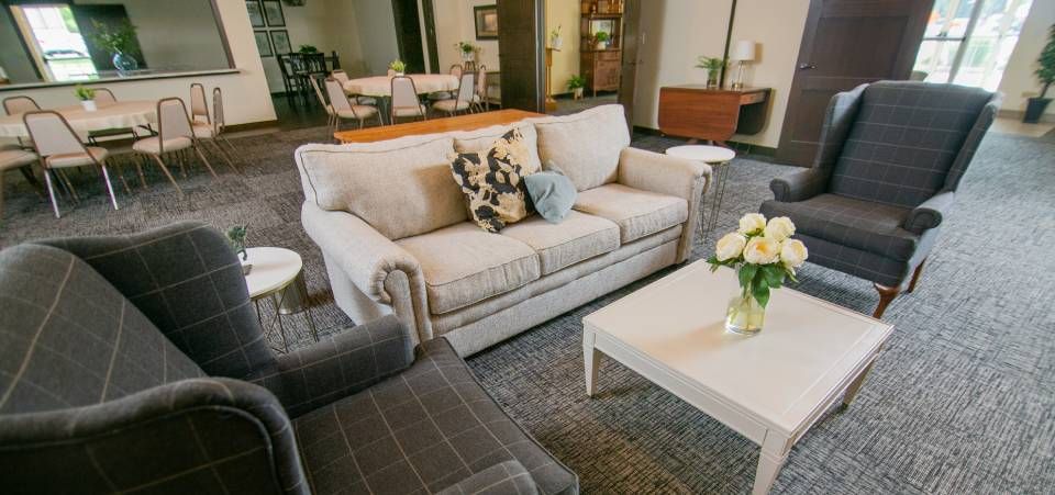 A living room with a couch , chairs , and a coffee table.