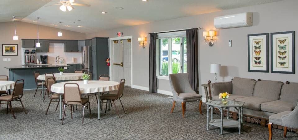 A large room with tables and chairs and a couch.