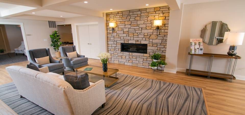 A living room with a couch , chairs , and a fireplace.