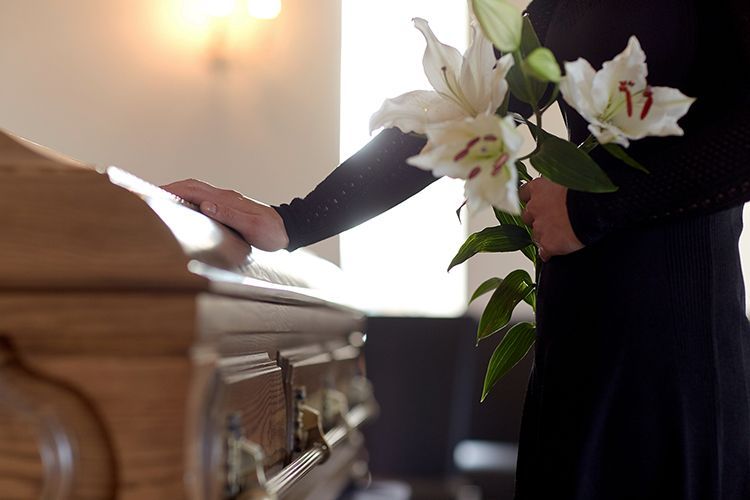 a wooden casket with flowers on top of it in a church .