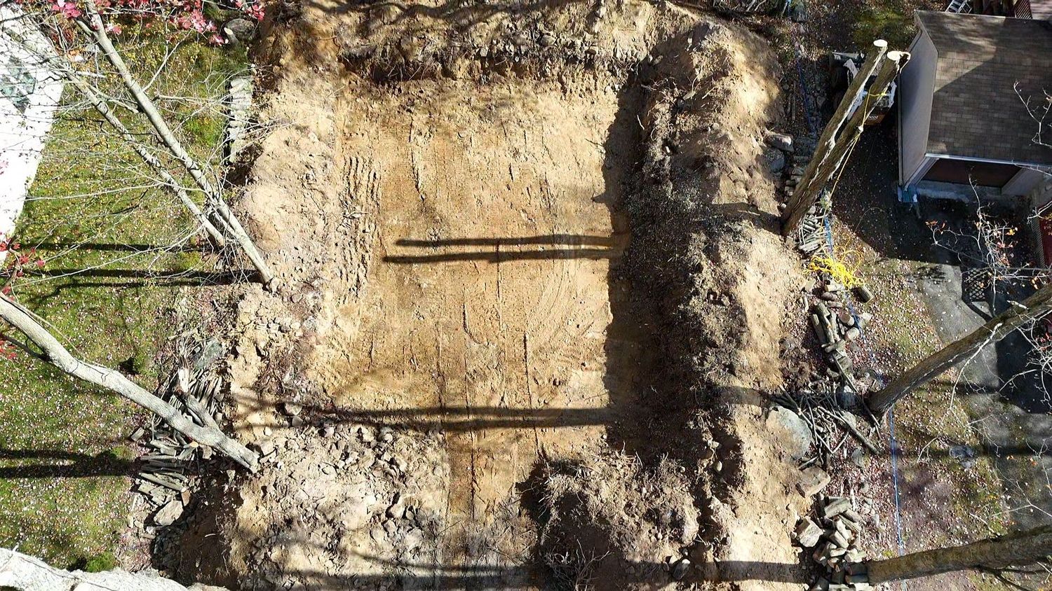 A large pile of dirt is sitting in front of a house.