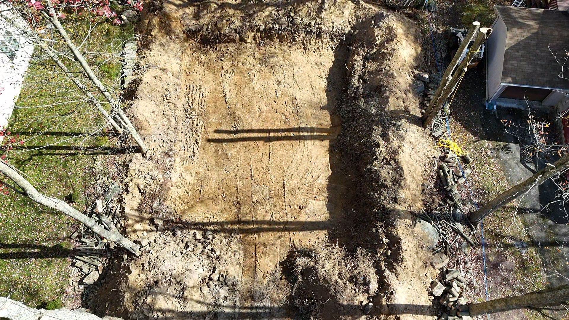 A large pile of dirt is sitting in front of a house.