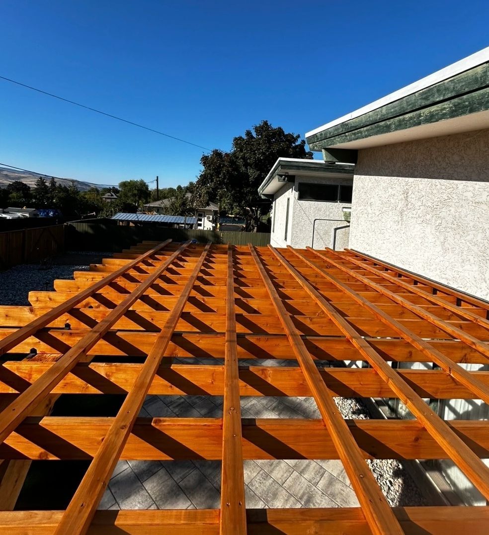 Wooden deck frame under construction with blue sky background.