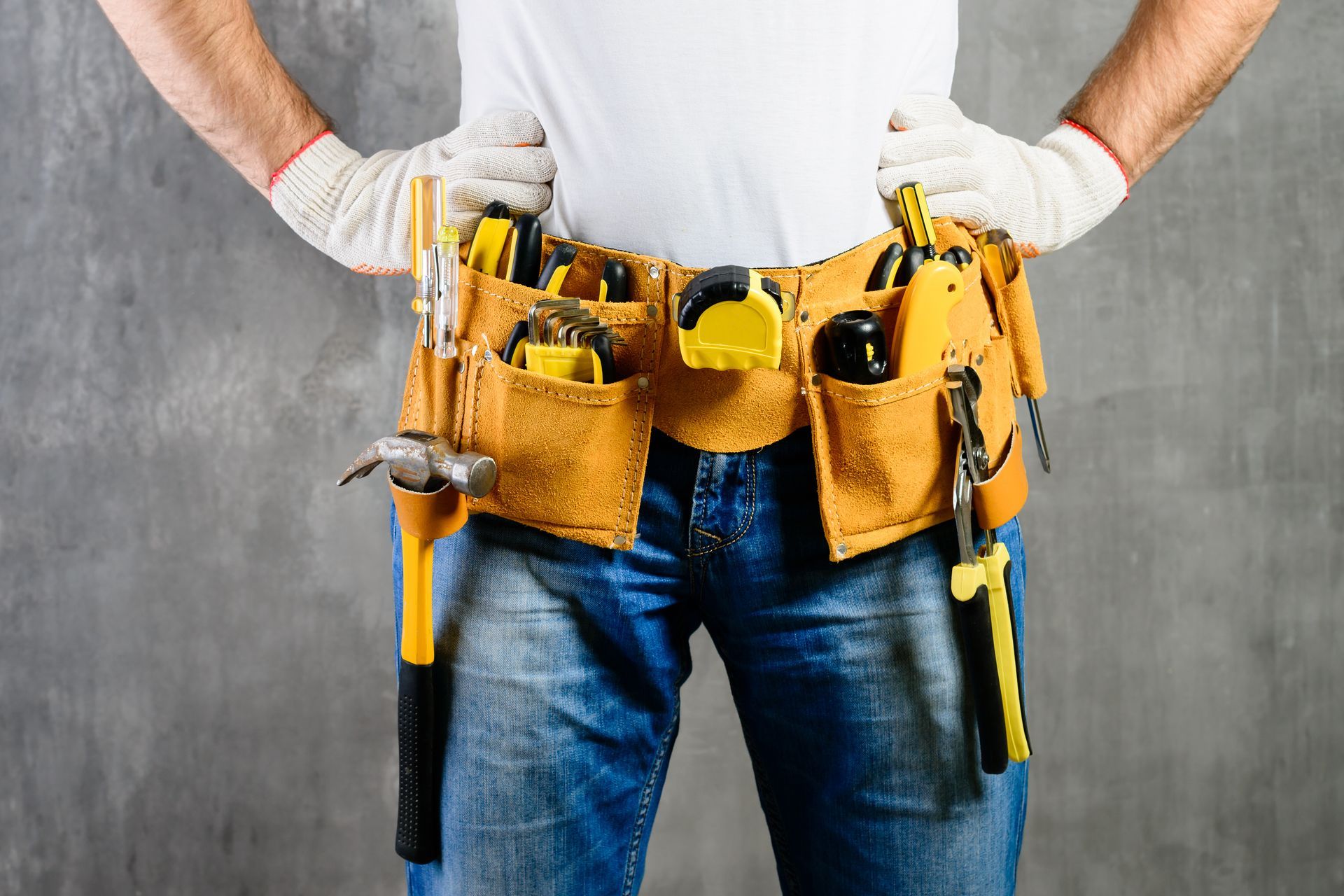 a man is wearing a tool belt with tools in it