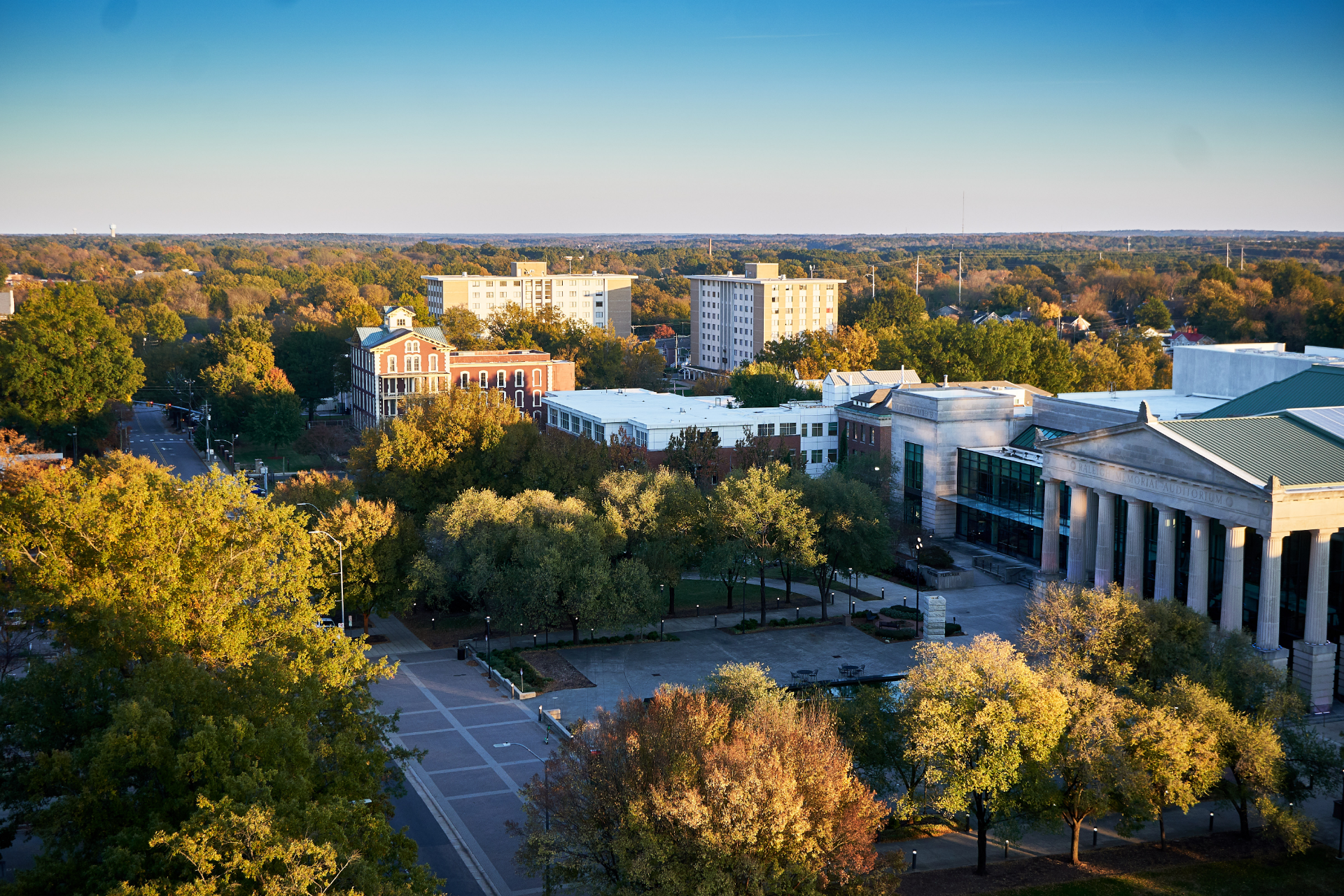 A man is sitting at a table with his arms crossed and smiling.