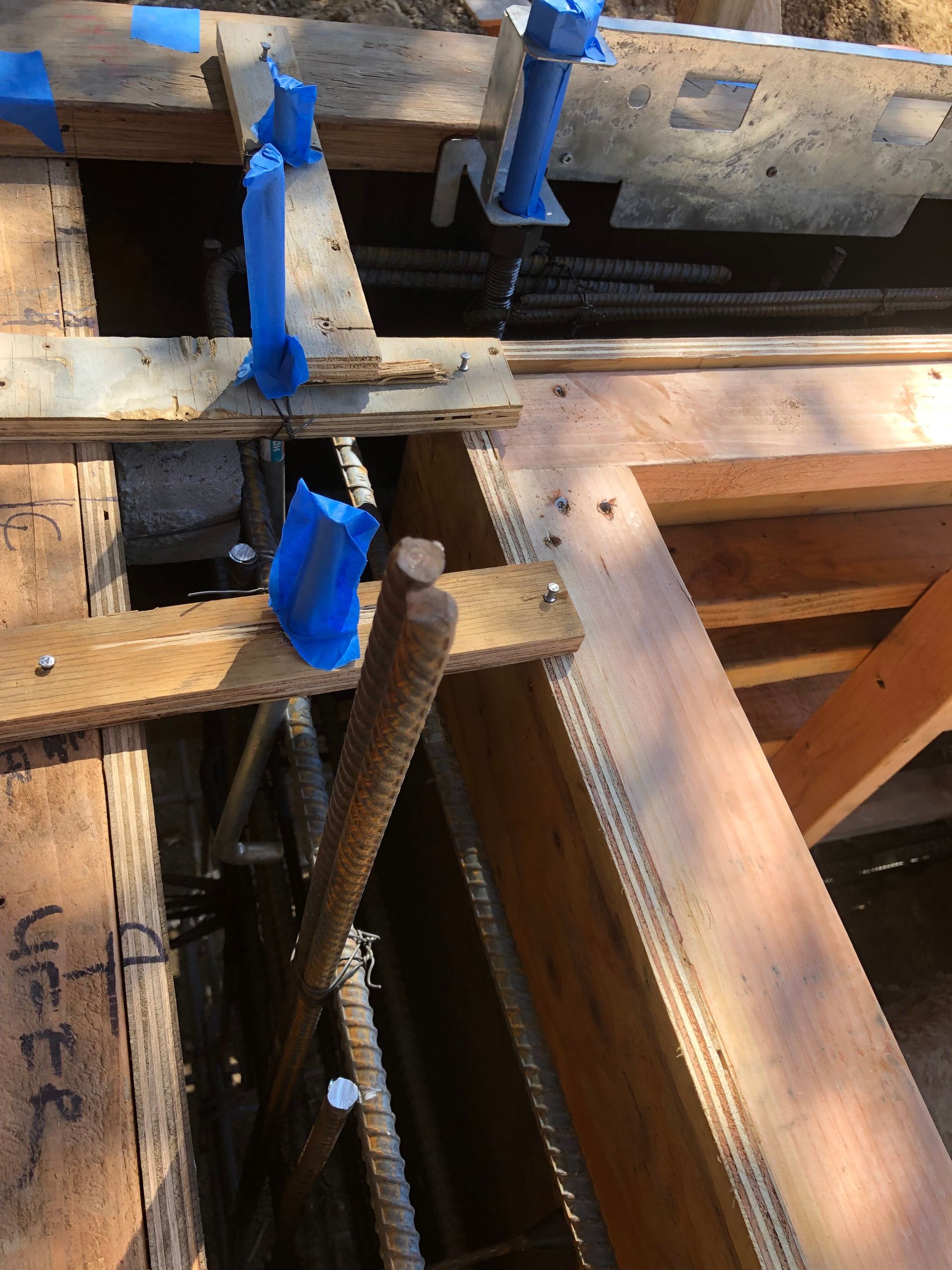 Wooden concrete formwork with rebar and adjustable supports, ready for pouring.