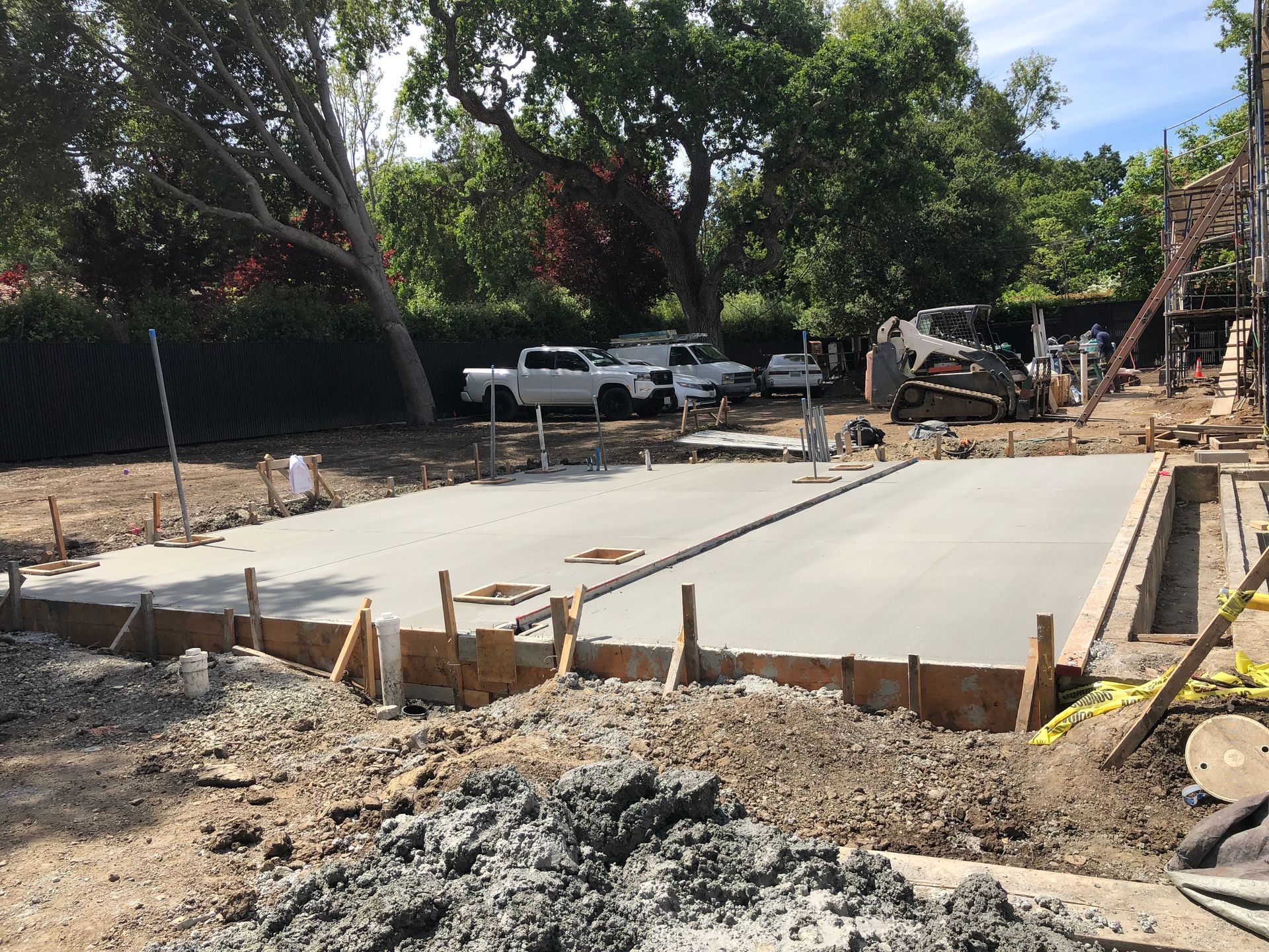 Newly poured concrete foundation with wooden frame, construction site.