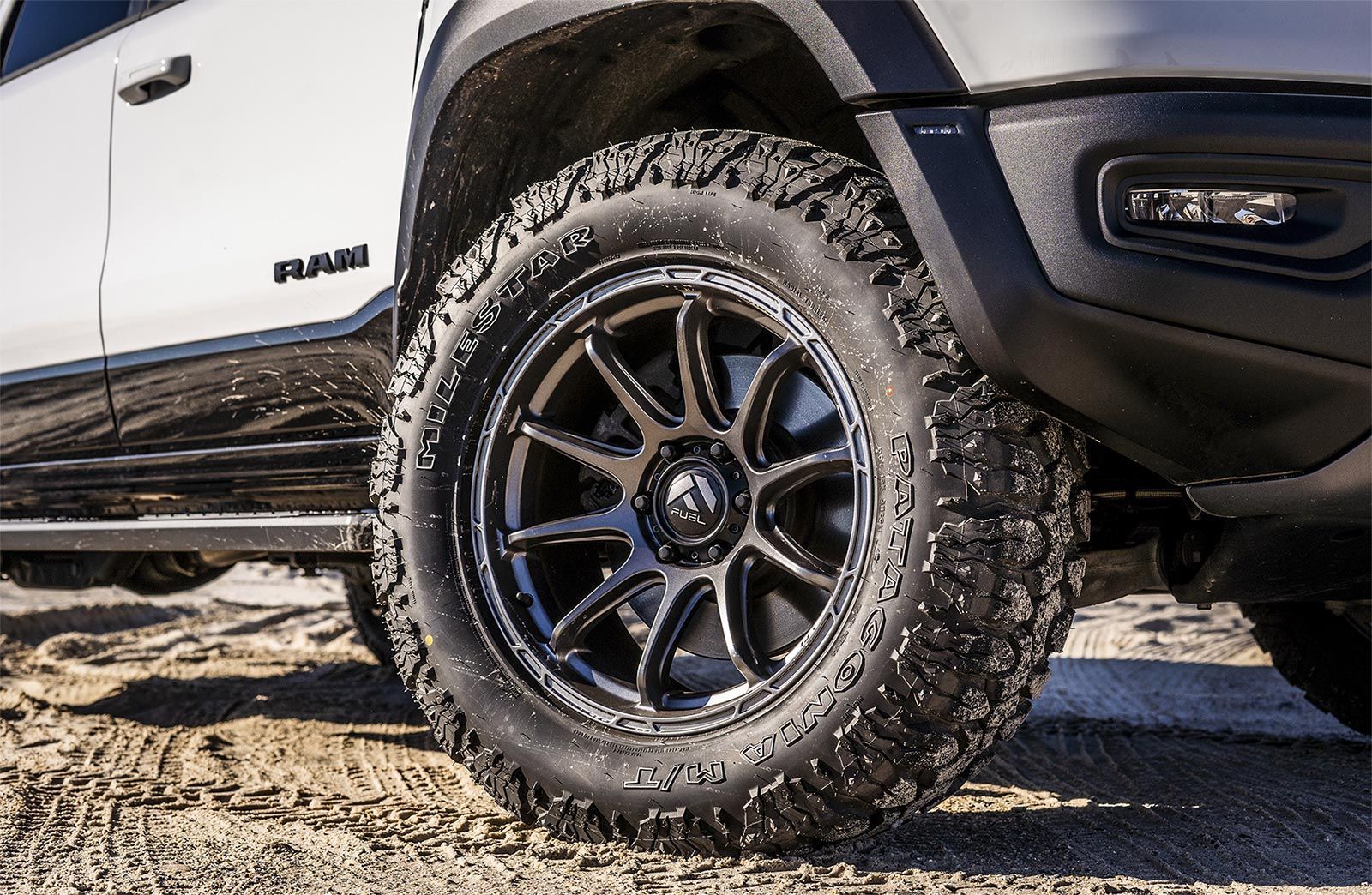 A white ram truck with black wheels and tires