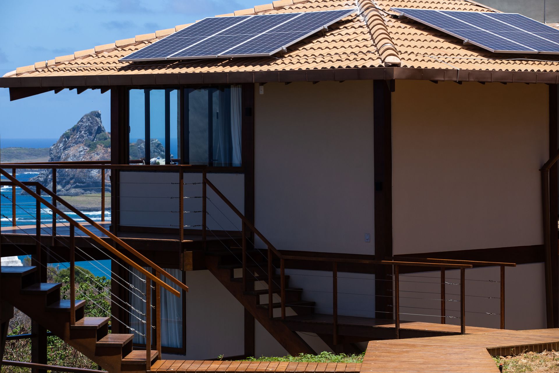 Uma casa com escadas e painéis solares no telhado