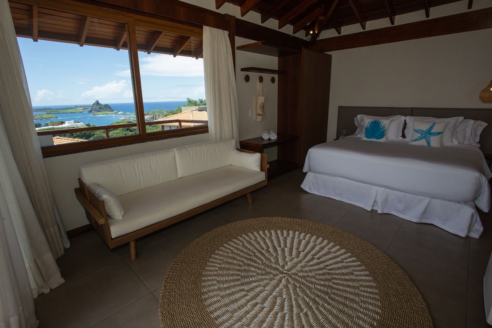 Um quarto de hotel com uma cama, sofá e tapete.