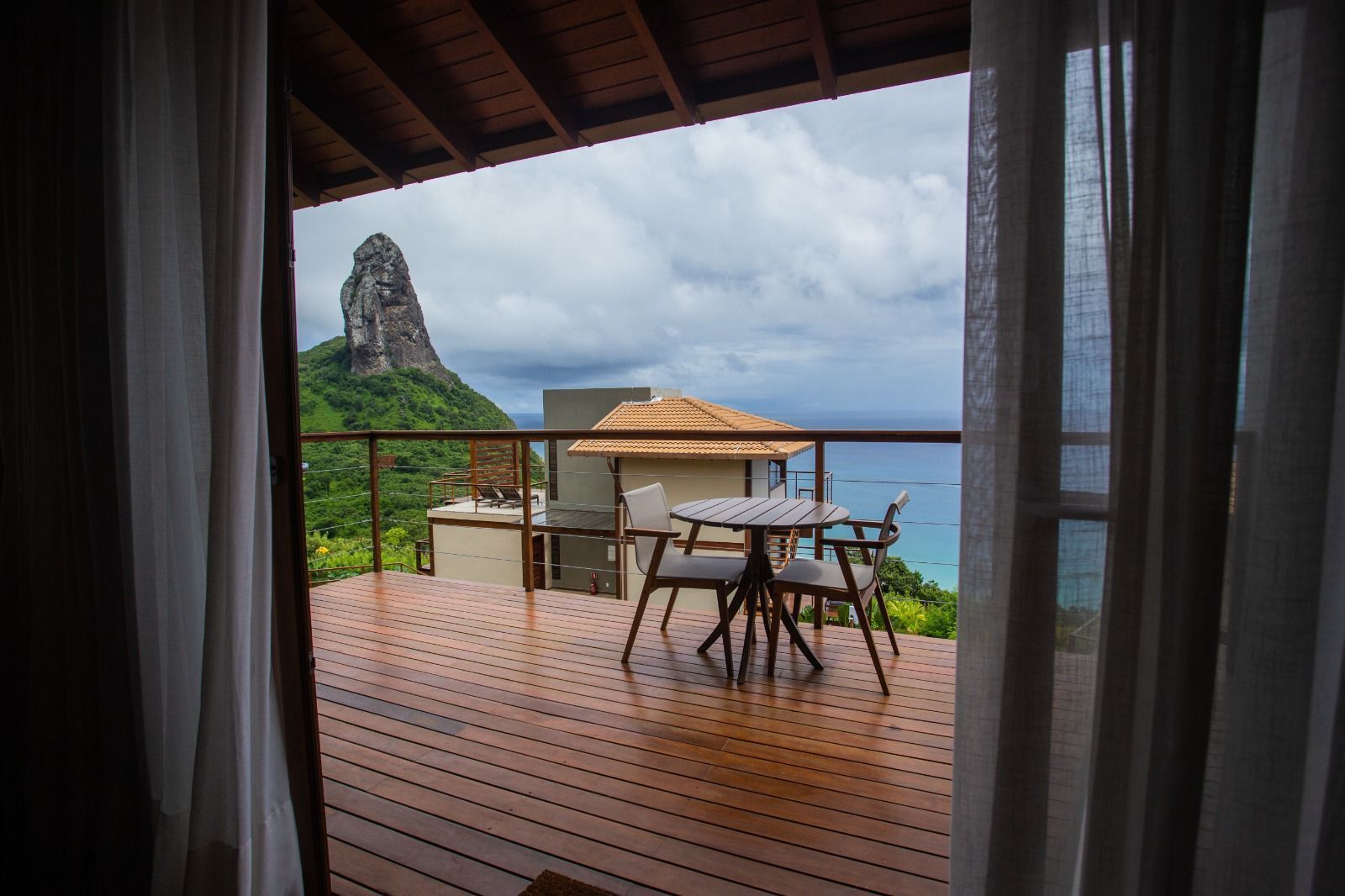 Uma varanda com mesa e cadeiras com vista para o oceano.