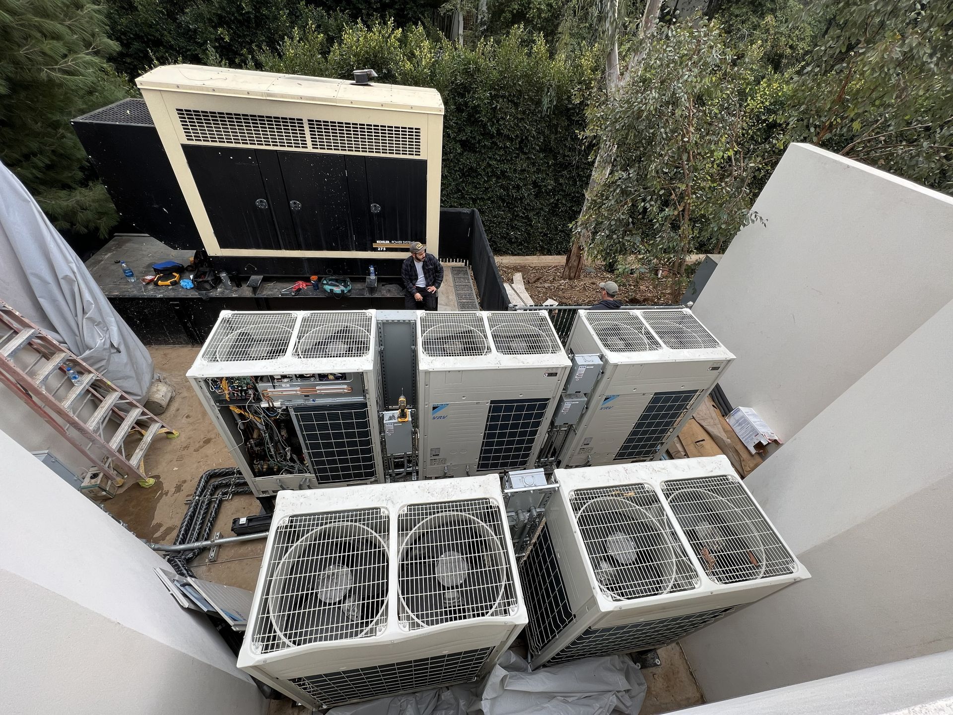 Aerial view of a building rooftop with numerous HVAC units and vents.